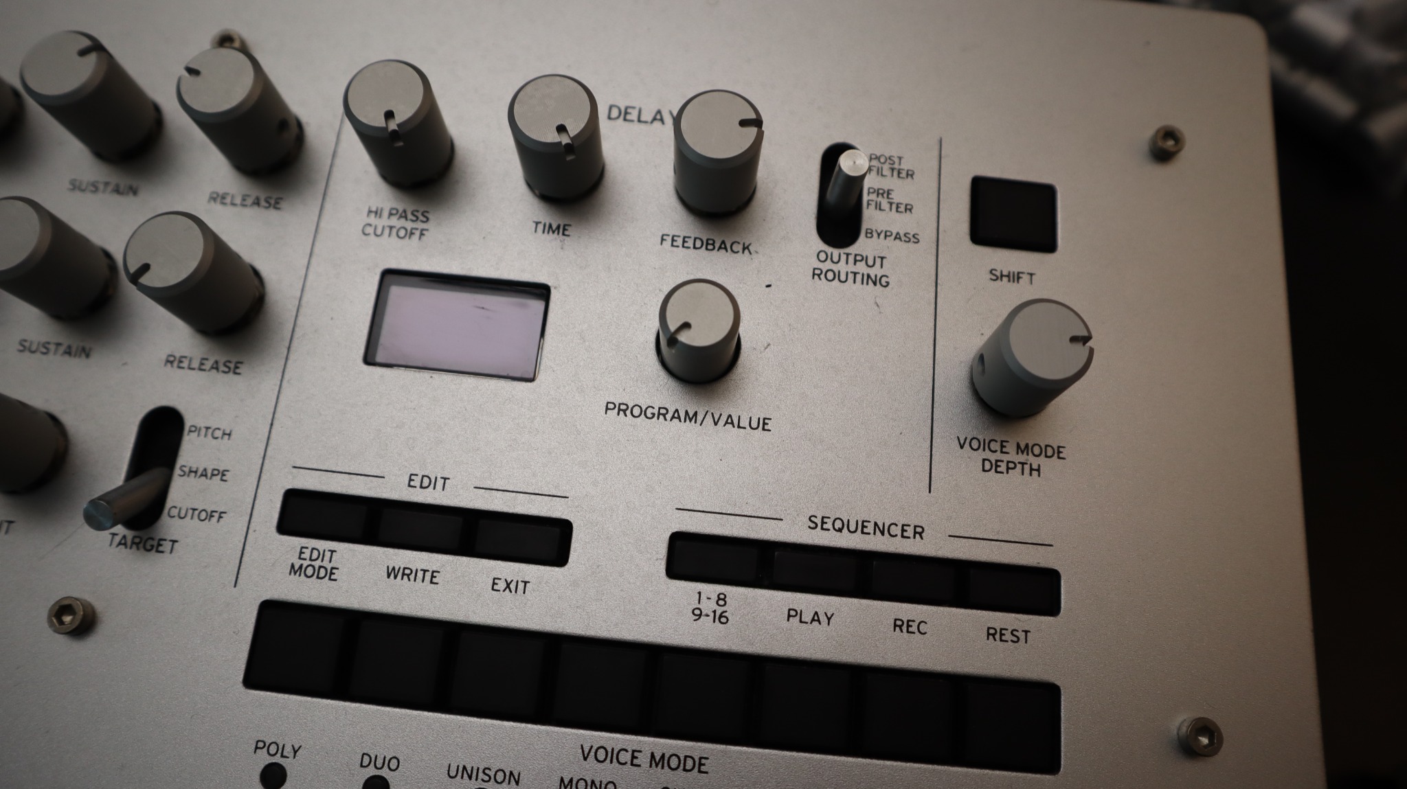 Close-up of replacement knobs on a silver Korg Minilogue around the program and delay section.