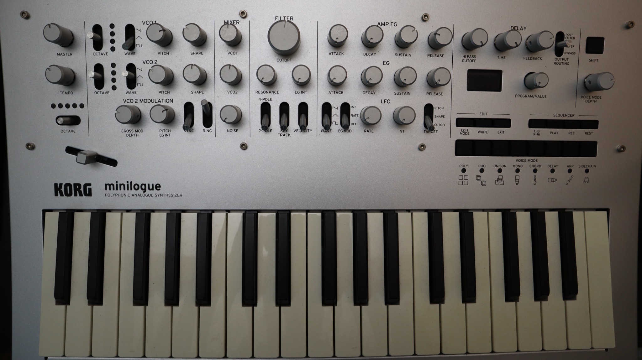 Top view of a silver Korg Minilogue with replacement knobs installed.